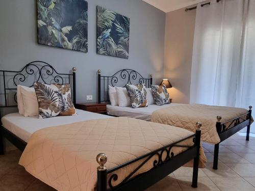 a bedroom with two beds with pillows at Marathon Studios & Apartments in Keri