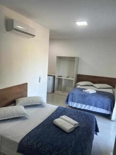 a bedroom with two beds with towels on them at Pousada casa da amizade in Penha