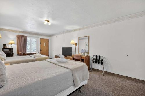 a hotel room with two beds and a mirror at Eagle Motel Suite 112 in Manitou Springs