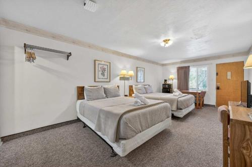 a hotel room with two beds and a table at Eagle Motel Suite 112 in Manitou Springs