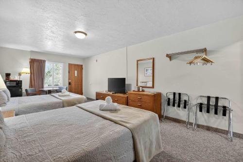 a hotel room with two beds and a television at Eagle Motel Suite 114 in Manitou Springs