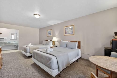 a hotel room with two beds and a table at Eagle Motel Suite 114 in Manitou Springs