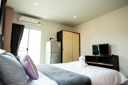 a hotel room with two beds and a refrigerator at At Ease Hotel Suvarnabhumi in Bang Phli