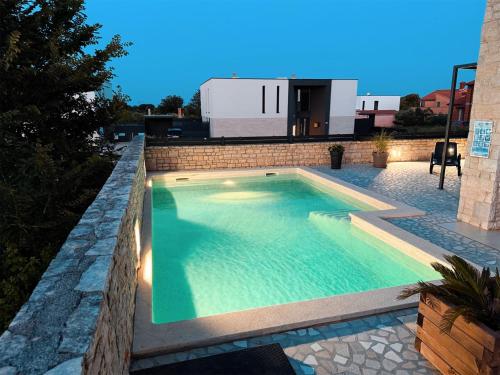 a swimming pool in a backyard with a house at Apartment Istra Mare private pool & parking in Ližnjan