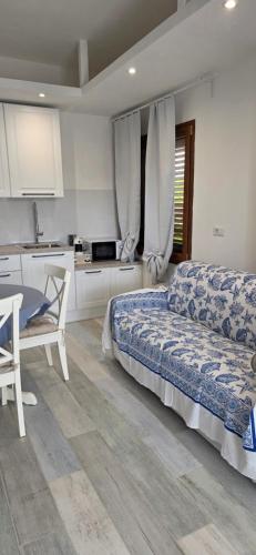 a bedroom with a bed and a table and a kitchen at Q Home San Teodoro Centro in San Teodoro