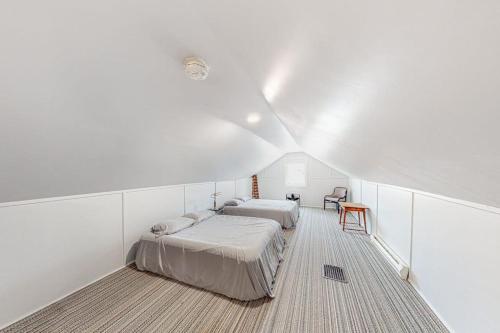 two beds in a room with white walls at Enchanting Adobe in Lead