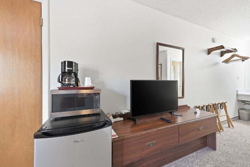 a living room with a tv on a wooden dresser at Eagle Motel Suite 226 in Manitou Springs