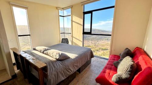a bedroom with a bed and a couch and windows at Olas de Pichicuy in Guaquen