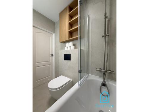 a white bathroom with a toilet and a shower at Harbor Room at City Center Gdynia & Seaside in Gdynia