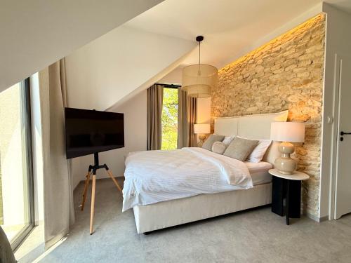 a bedroom with a bed and a stone wall at BOGORIA Apartments in Uniejow