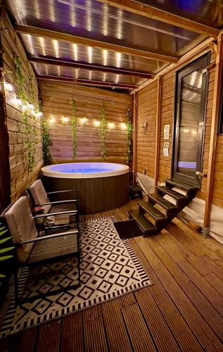 a large bathroom with a tub and some chairs at Romantic Tiny House with Private Jacuzzi and Garden between Amsterdam Haarlem and Schiphol Airport in Vijfhuizen