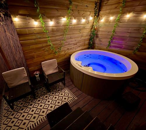 a jacuzzi tub in a wooden room with lights at Romantic Tiny House with Private Jacuzzi and Garden between Amsterdam Haarlem and Schiphol Airport in Vijfhuizen
