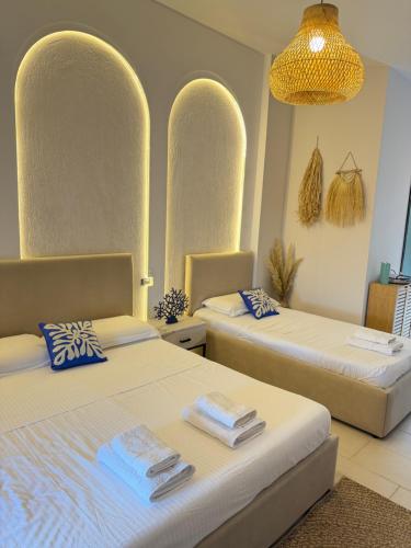 a bedroom with two beds with towels on them at Hotel Imperial in Dhërmi