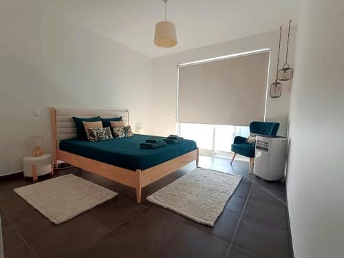 a bedroom with a bed with green sheets and a window at AuraHouse Algarve in Lagoa