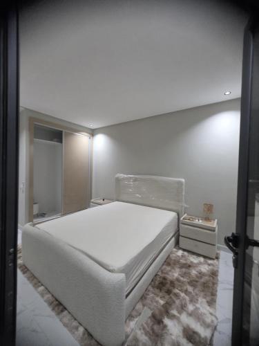 a bedroom with a white bed in a room at Dar D'Asilah in Asilah