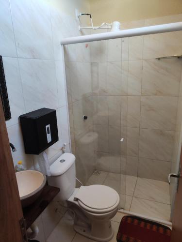 a bathroom with a shower and a toilet and a sink at Hostel Leda Beach in Canoa Quebrada