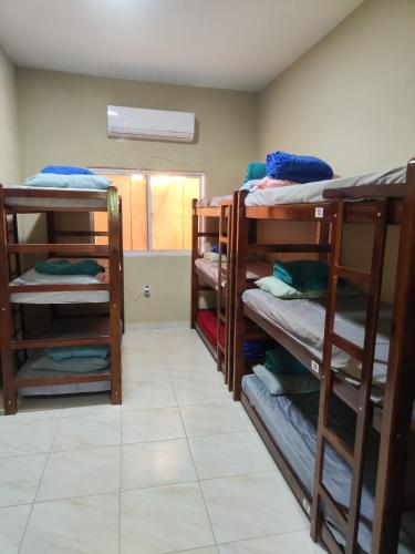 a room with three bunk beds in a room at Hostel Leda Beach in Canoa Quebrada