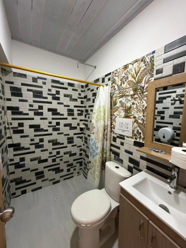 a bathroom with a toilet and a sink at Hotel Sol del Magdalena in La Dorada