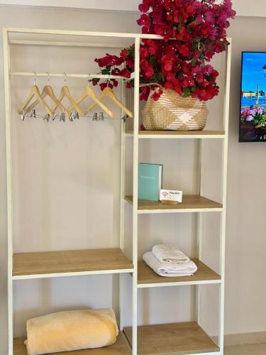 a white closet with shoes and a basket of flowers at Hotel Imperial in Dhërmi