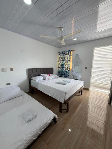 a bedroom with two beds and a ceiling fan at Hotel Sol del Magdalena in La Dorada