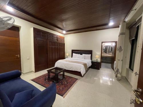 a bedroom with a bed and a blue couch at Heritage Cottage Kashmir Point in Murree