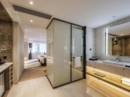a bathroom with a glass shower and a sink at Mercure Panjin in Panjin