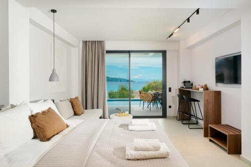a white living room with a white couch and a balcony at Ethos Zeen Private Pool Suites in Potamiá