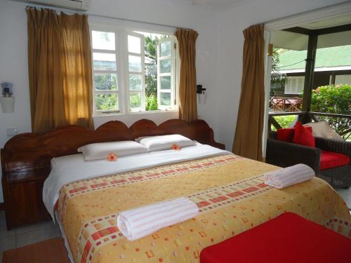 a bedroom with a large bed with towels on it at Chez Michellin Pensions Residence in La Digue