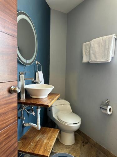 a bathroom with a white toilet and a sink at Hotel La Bikina in Tequila
