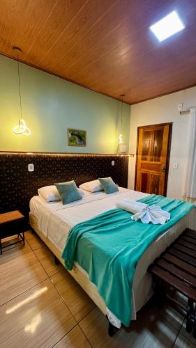 a bedroom with a large bed with a blue blanket at Pousada São José in Barreirinhas