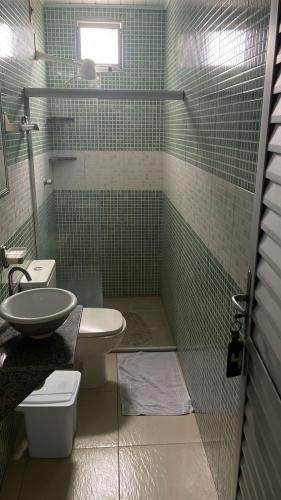 a bathroom with a toilet and a sink and a shower at Pousada Recanto Bella Vista in Saubara