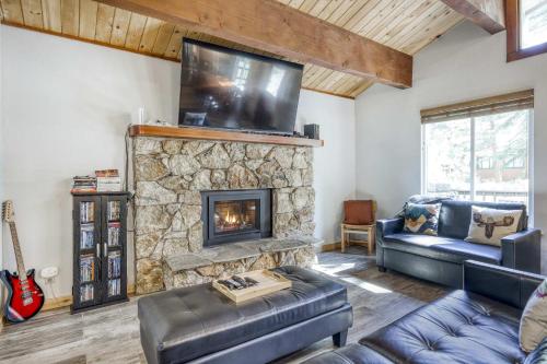 a living room with a stone fireplace with a tv at Northstar Cabin Escape in Truckee