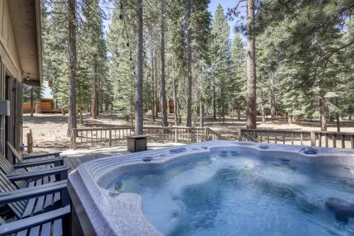 a hot tub on a porch with trees in the background at Northstar Cabin Escape in Truckee