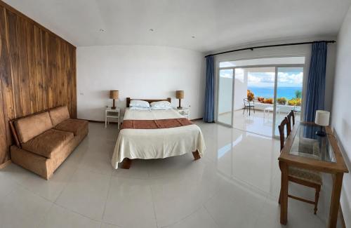 a bedroom with a bed and a couch and a table at Hotel Punta Blanca - Jama - Manabí in Jama