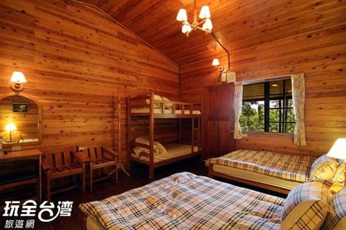 Da Kuan Peach Farm Resort في Hualing: غرفة نوم بسريرين في كابينة خشب