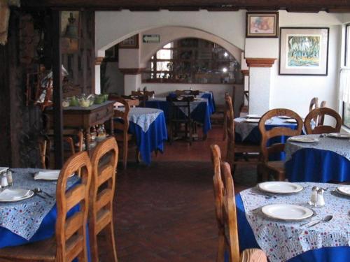 a dining room with tables and chairs with blue table cloth at Hotel La Posada in Apizaco