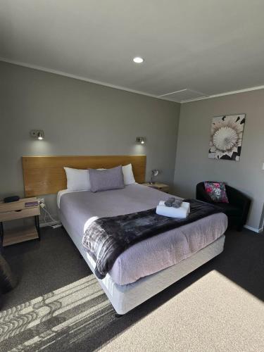 a bedroom with a large bed in a room at Commodore Court Motel in Blenheim