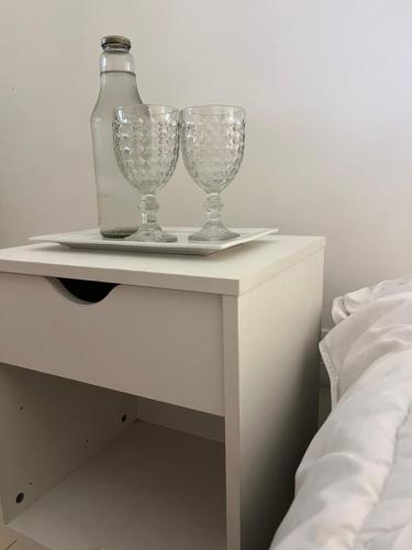 two wine glasses on a table next to a bed at Areal in Areal