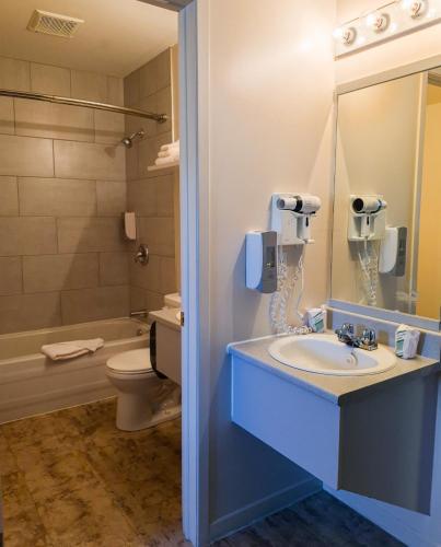 a bathroom with a sink and a toilet and a phone at Motel de l'Anse a l'Eau in Tadoussac