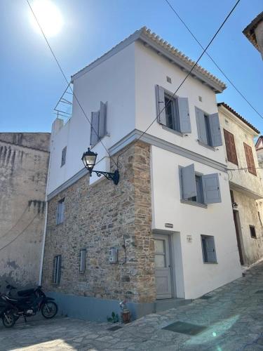 a large white building with a motorcycle parked next to it at Samos Vista Azzurra 1 in Samos