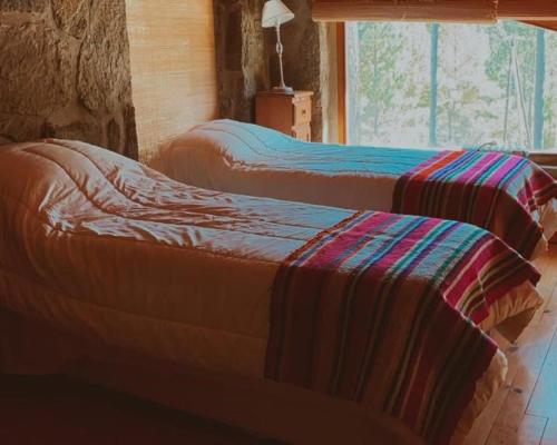 two beds sitting in a room with a window at Huellas de Berna in Villa Berna