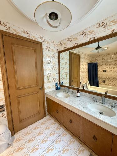 a bathroom with two sinks and a large mirror at Casa Bosques in Mexico City