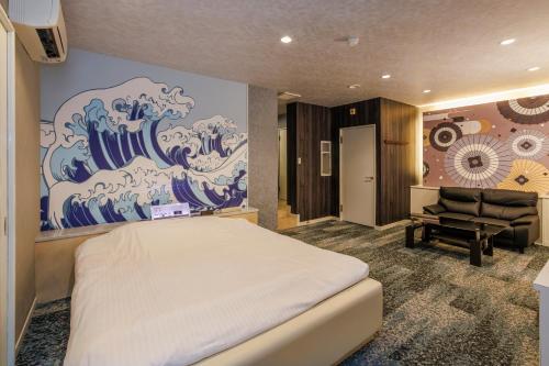 a bedroom with a large painting on the wall at HOTEL Lien in Ashiya