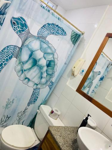 a bathroom with a sea turtle mural on the wall at Hostal Marysol in Puerto Ayora