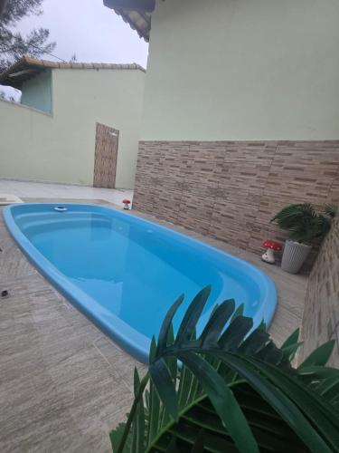 a large blue swimming pool in a yard at Casa com Piscina Privativa e Área Gourmet in Rio das Ostras