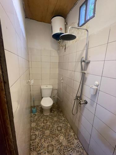 a small bathroom with a toilet and a shower at Marysa Lodge in Kotu