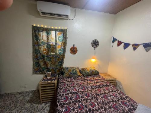 a bedroom with a bed with a curtain and a fan at Marysa Lodge in Kotu