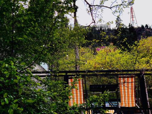 a fence with trees and a tower in the background at Funicular Inn Apartments in Tbilisi City