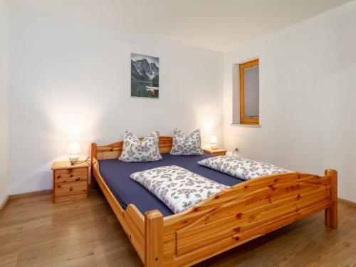 a bedroom with a wooden bed and two lamps at Apartment Birgit in Zellberg