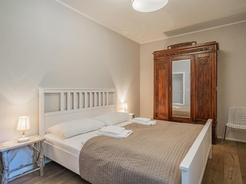 a bedroom with a large bed and a wooden cabinet at Kitz Apartments Top 1 in Kitzbühel
